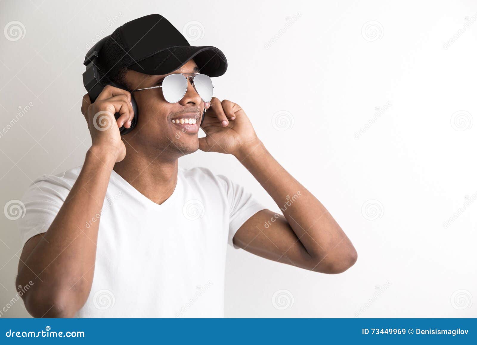smiling-black-guy-headphones-portrait-african-american-cap-sunglasses-listening-to-music-light-background-73449969.jpg