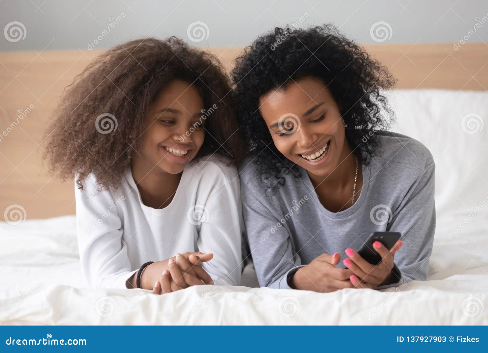 Smiling Black Mom and Daughter Relax with Smartphone in Bed Stock Image - Image of lifestyle, gadget: 137927903 Smiling Black Mom and Daughter Relax with Smartphone in Bed Stock Image - Image of lifestyle, gadget: 137927903