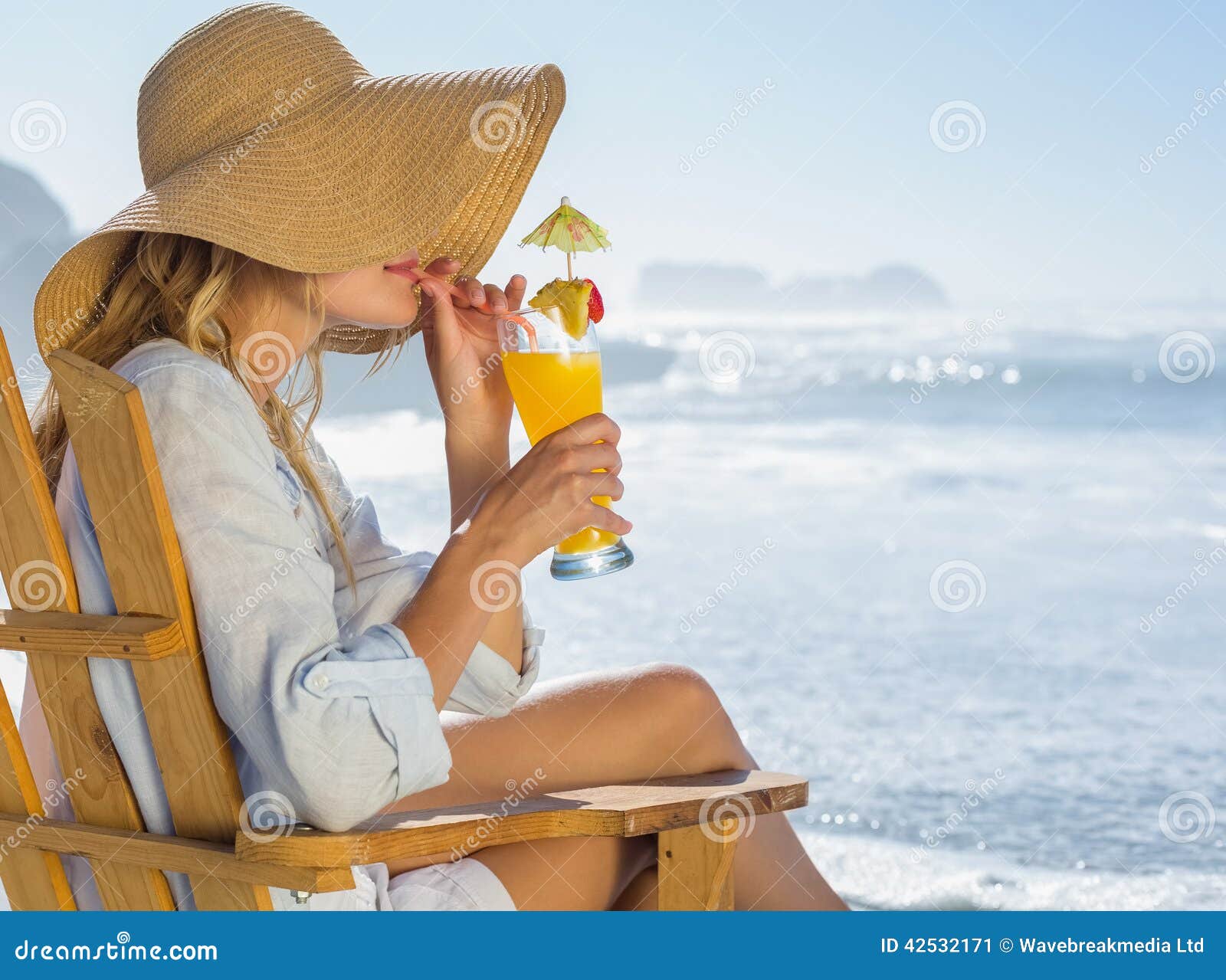 Smiling Blonde Relaxing in Deck Chair by the Sea Sipping Cocktail Stock ...