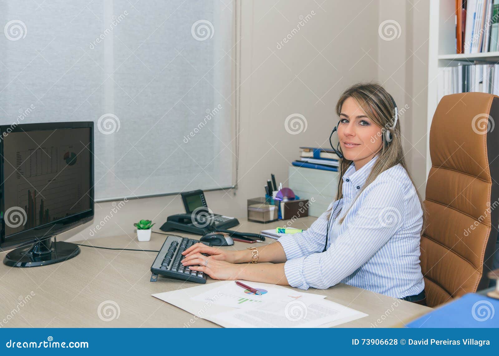smiling blonde secretary working with computer in office