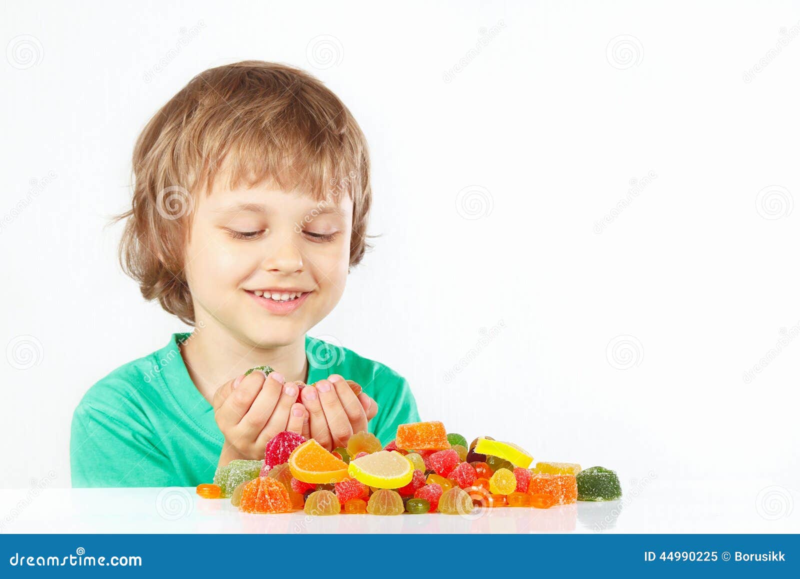 Smiling Boy with Colored Sweets and Jelly Candies on White Background