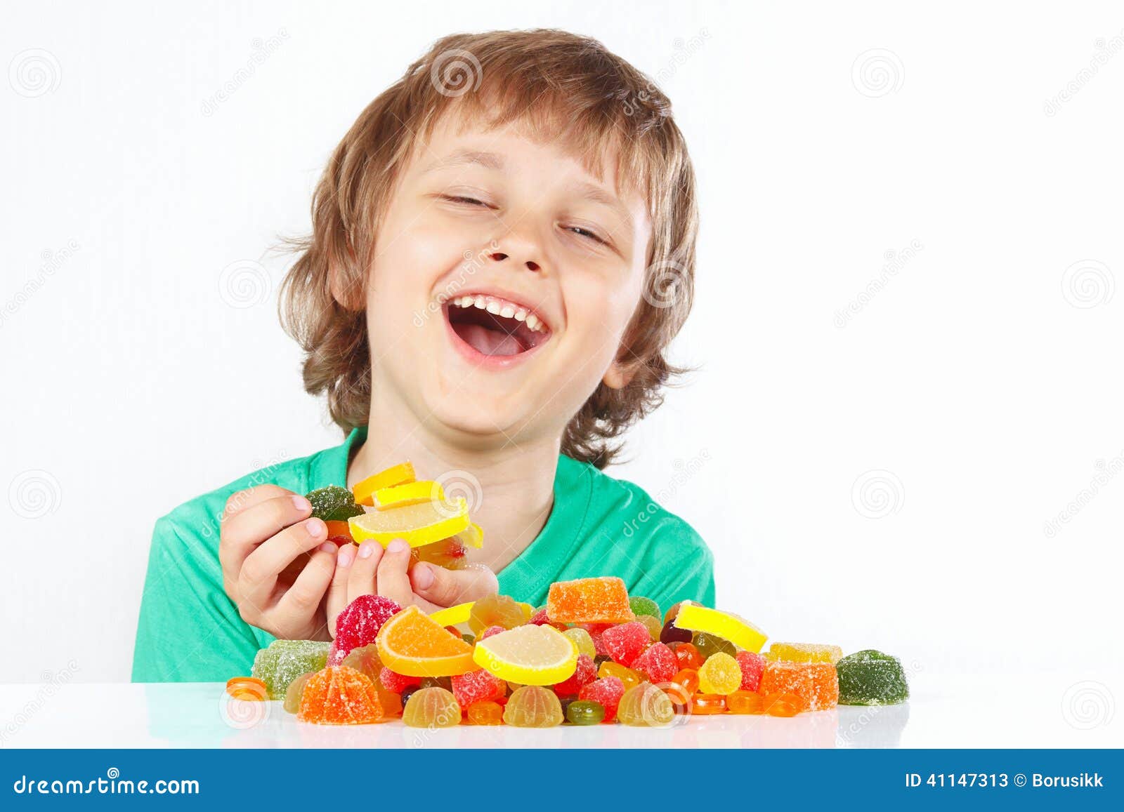Smiling Boy with Sweets and Jelly Candies on White Background Stock