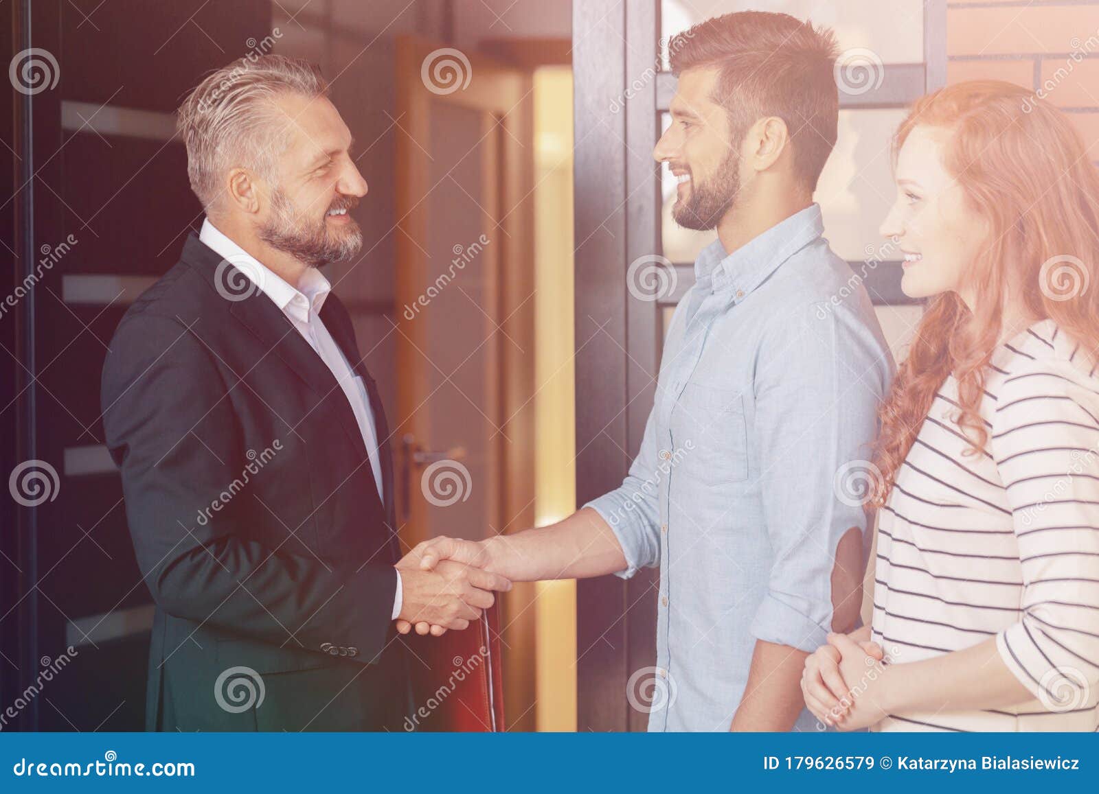 businessman congratulating happy couple buying flat