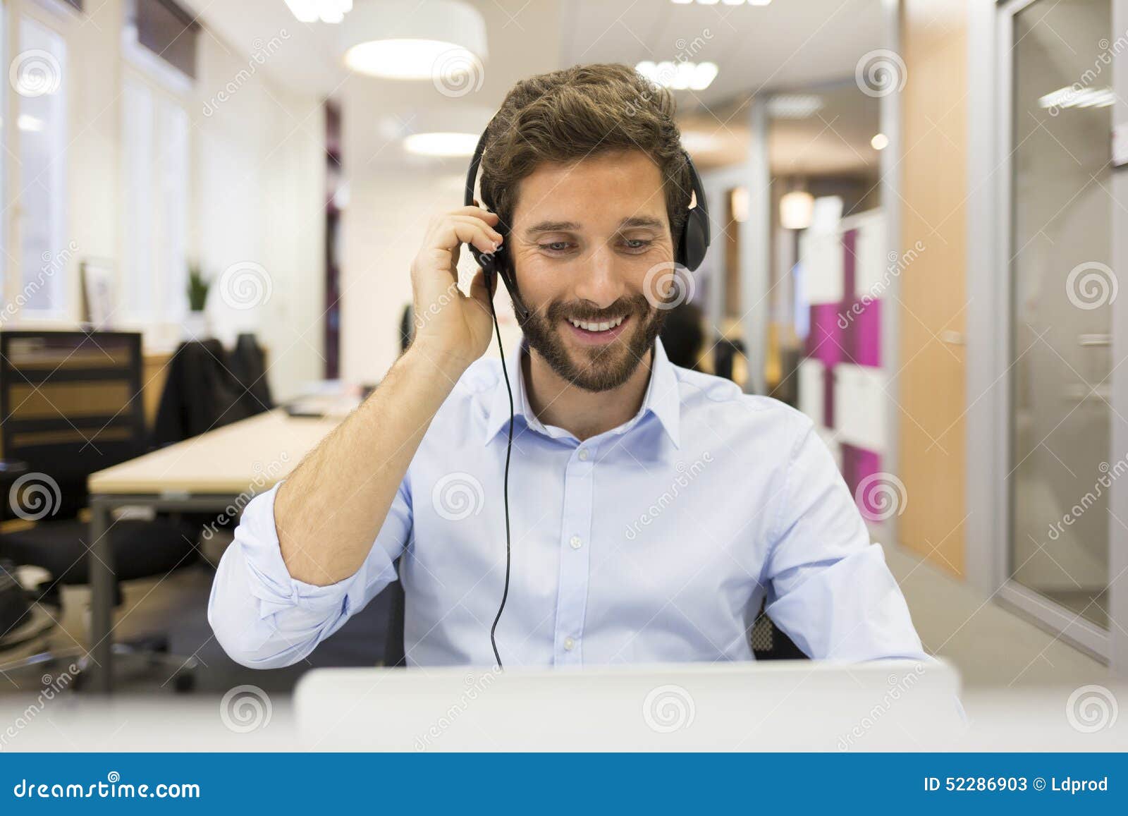 Smiling Businessman in the Office on Video Conference, Headset, Stock