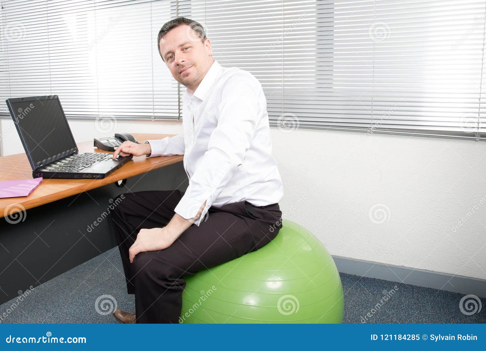 Businessman Sitting On Exercise Balloon At Desk Ball Seat Office