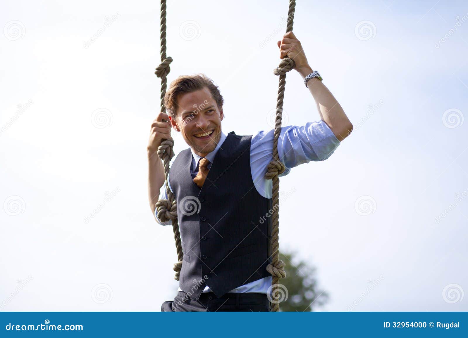 smiling businessman swinging in ropes
