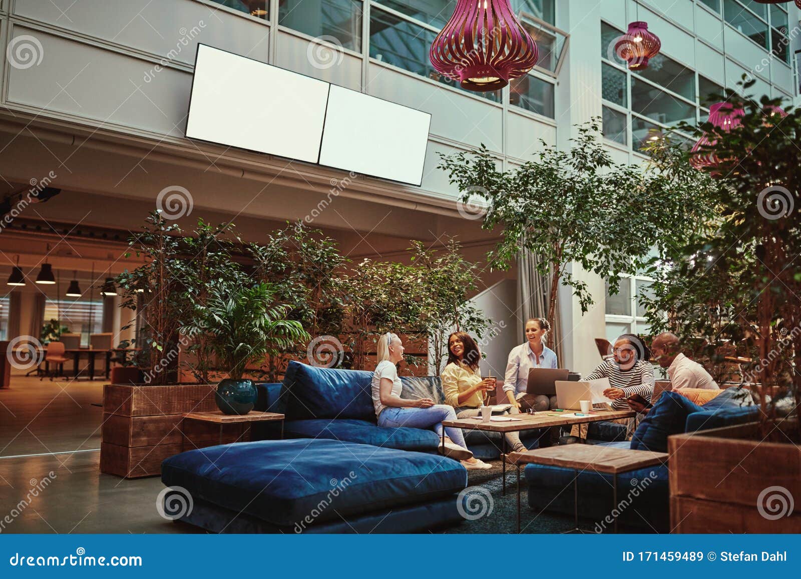 smiling businesspeople relaxing in the lounge area of an office