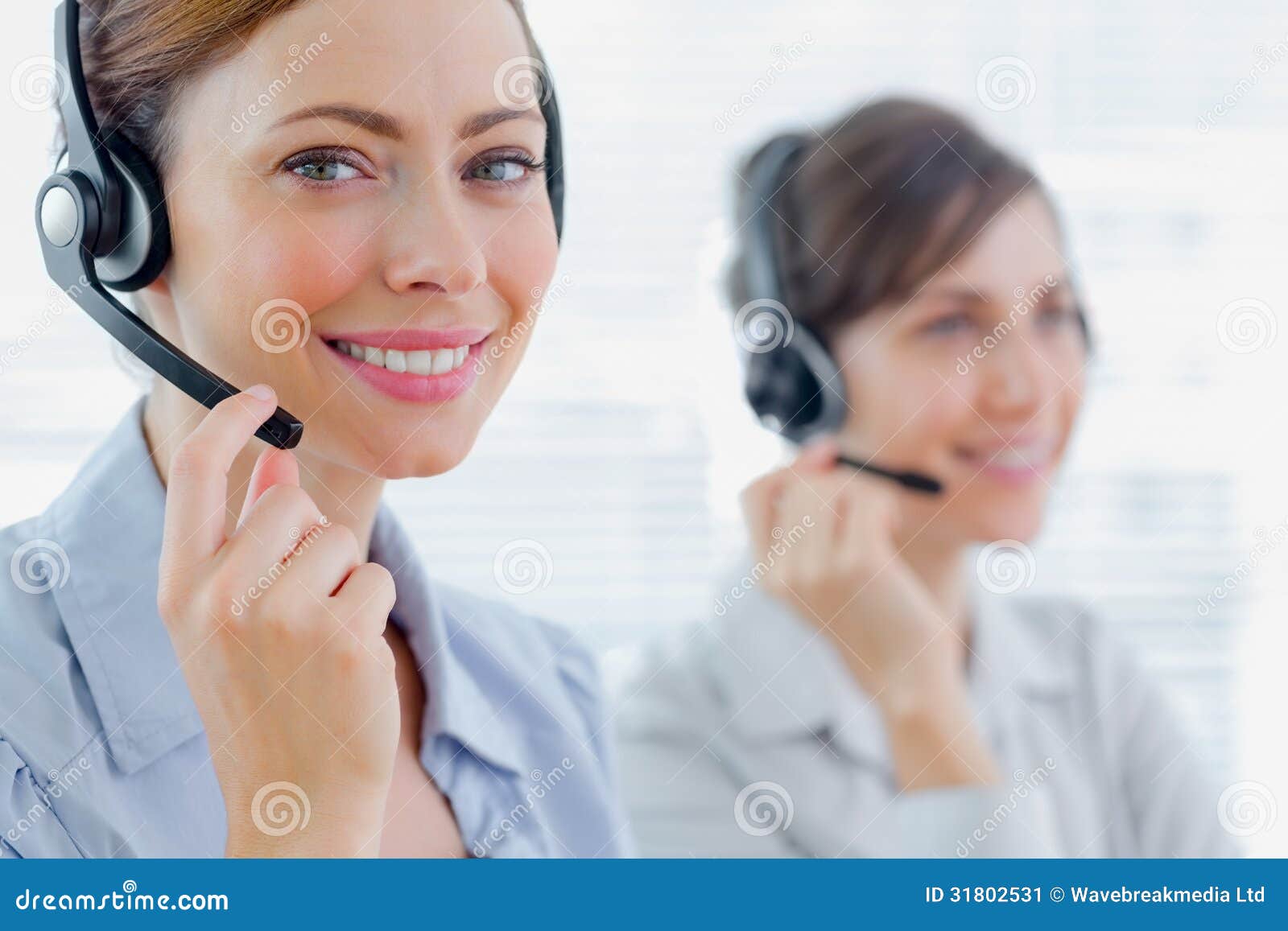 smiling call centre agents with headsets at work