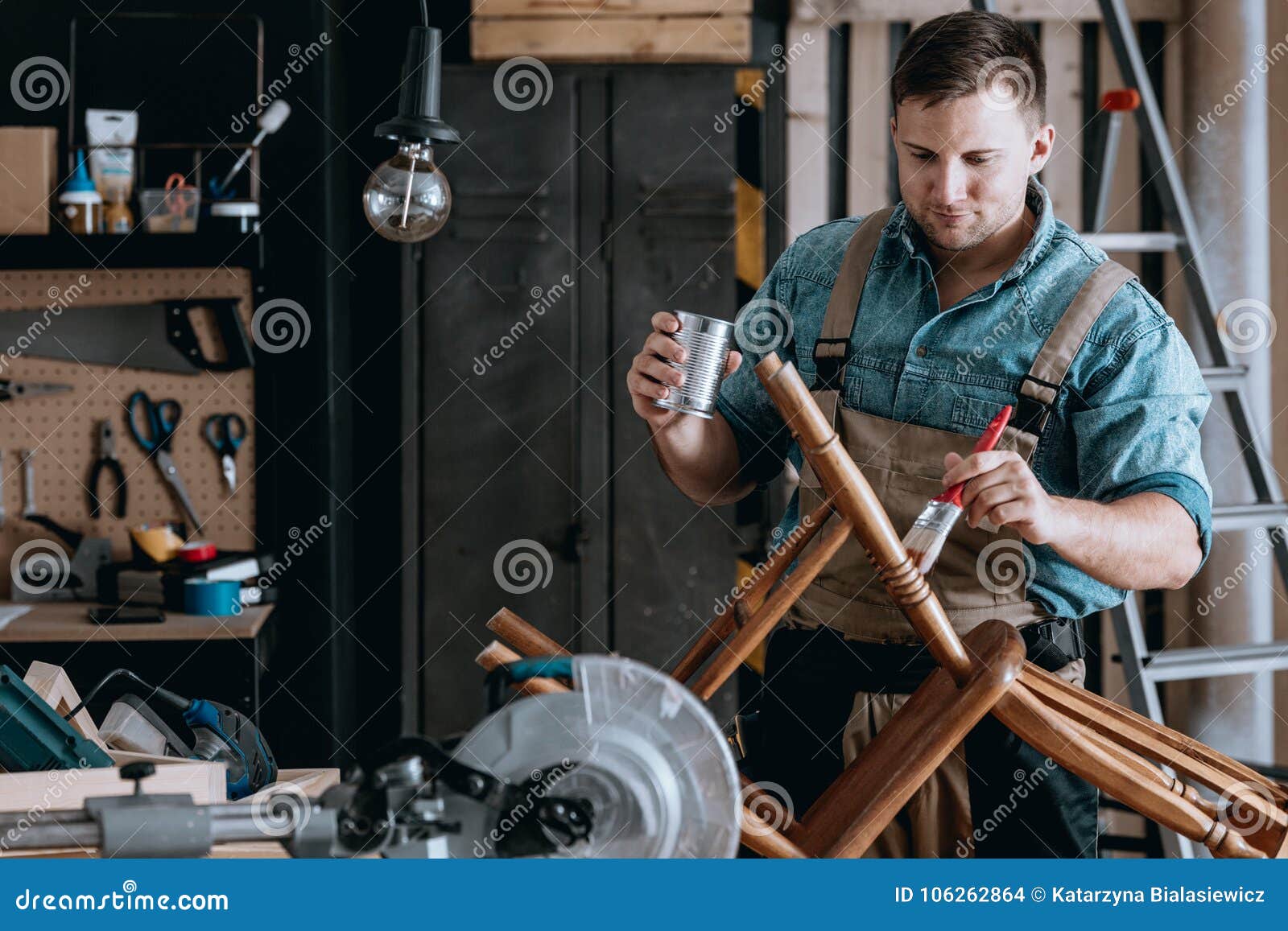 smiling carpenter renovating wooden chair