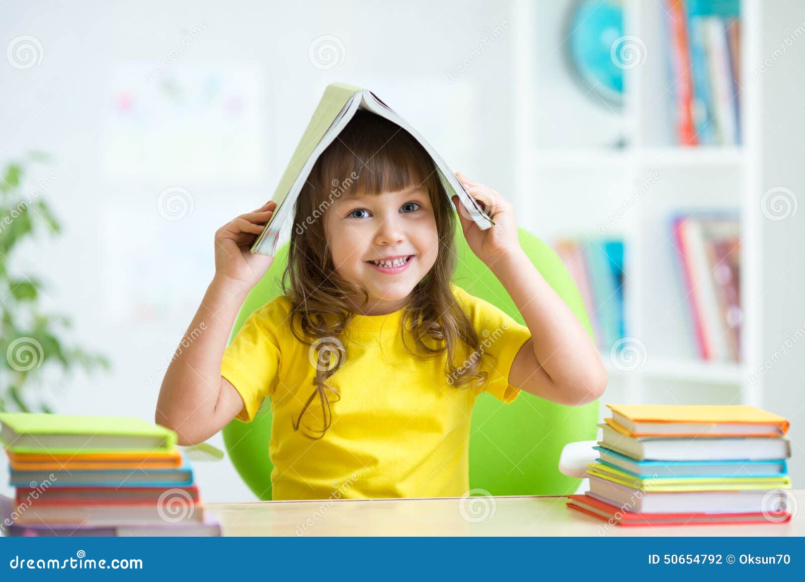 Smiling Child with a Book Over Her Head Stock Photo Image of