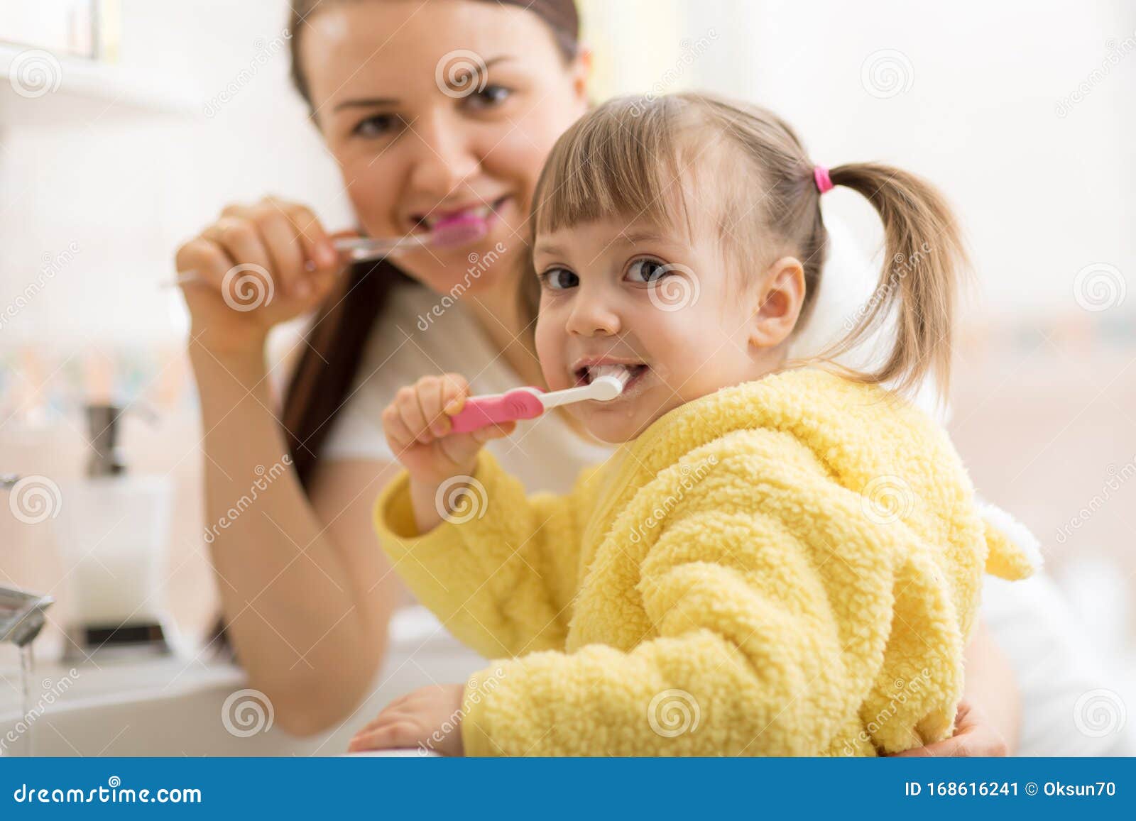 Smiling Child Kid With Her Mom Brushing And Clean Teeth In ...