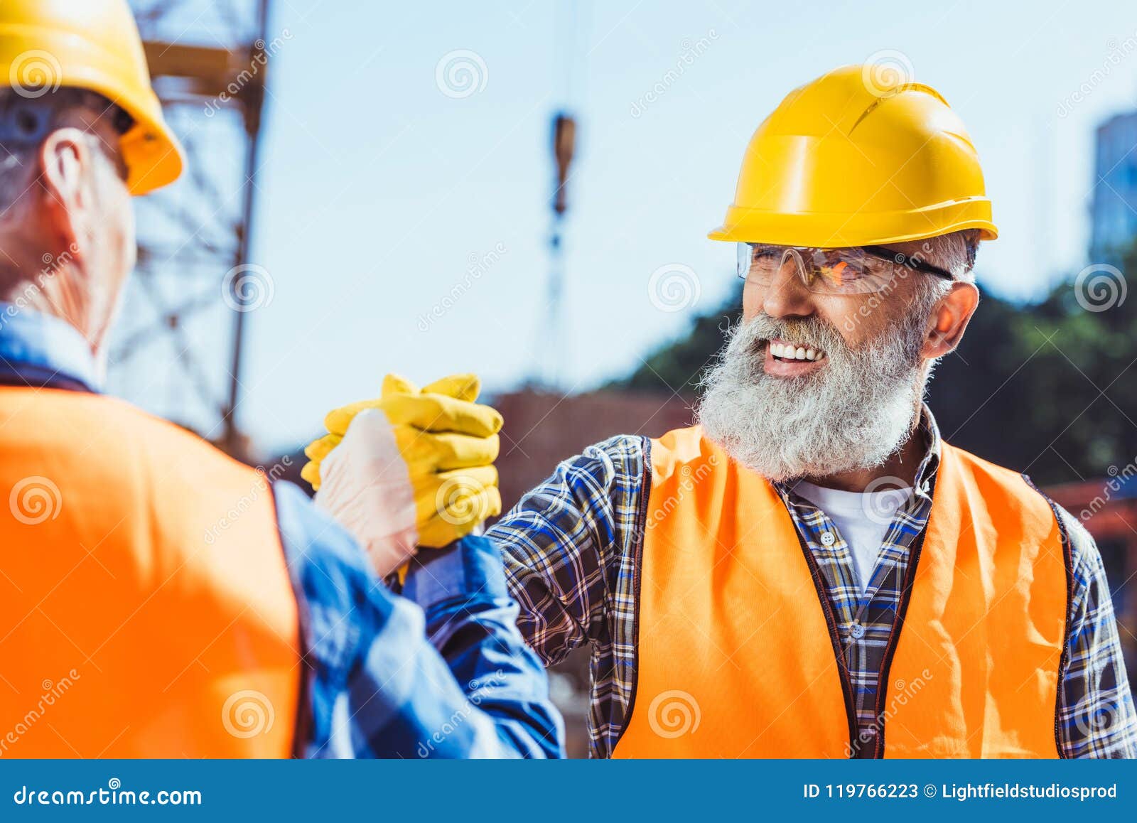Smiling Construction Worker in Protective Uniform Shaking Hands Stock