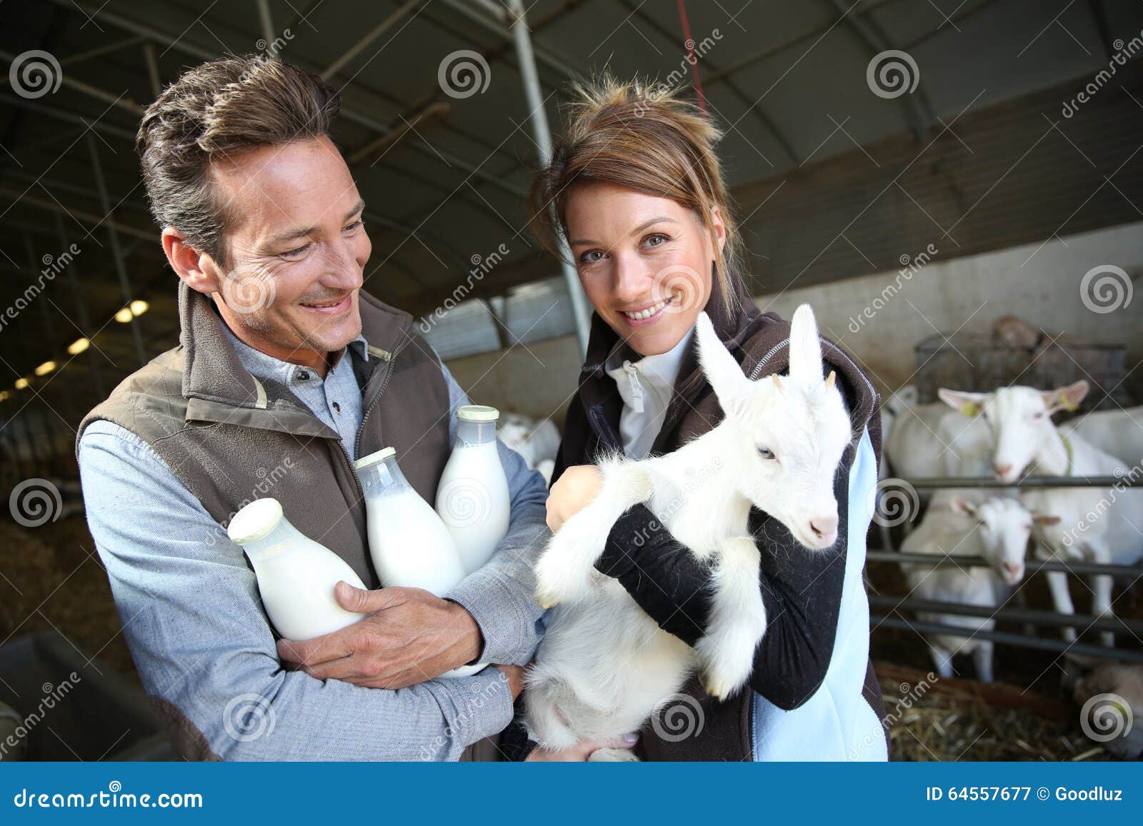 smiling couple of breeders with goat