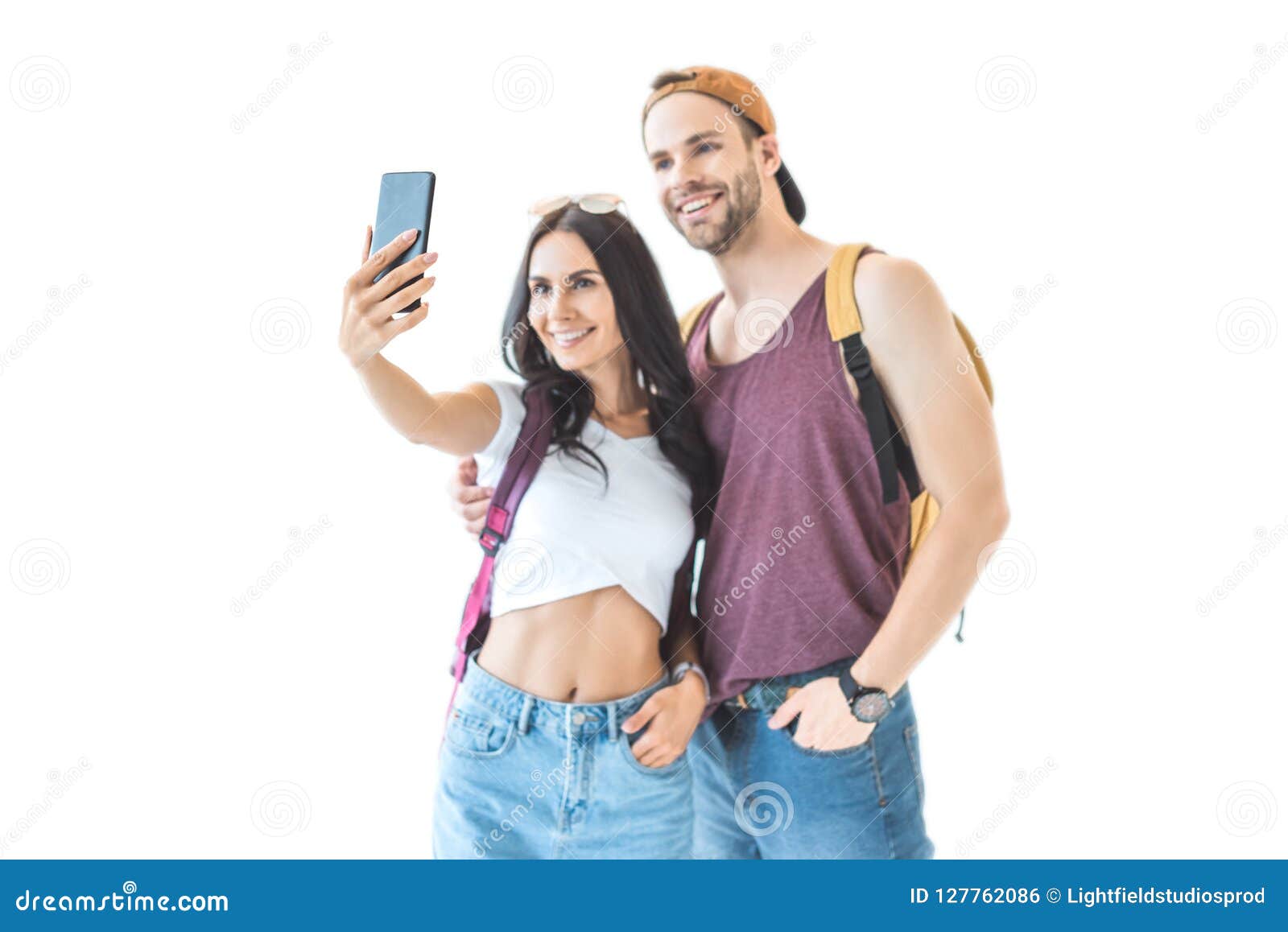 smiling couple of tourists taking selfie on smartphone