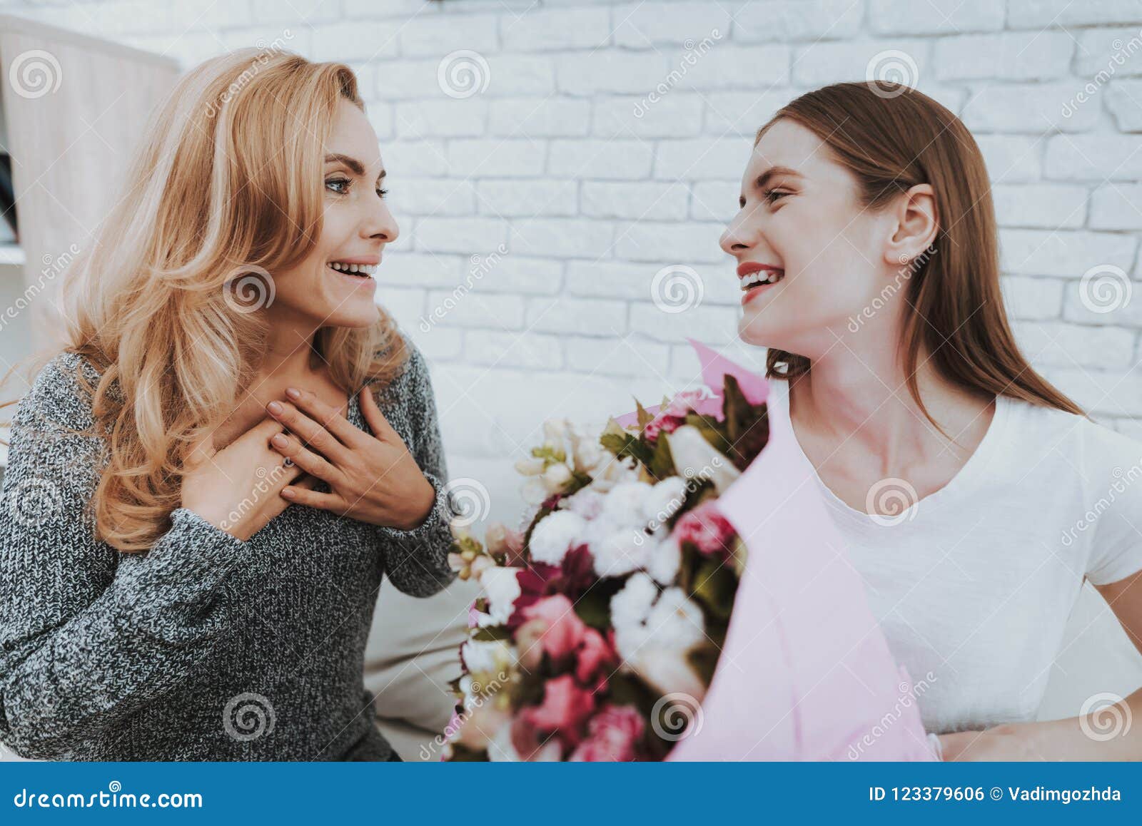 Smiling Daughter Gives Mother Flowers and Gift. Stock Photo - Image of ...