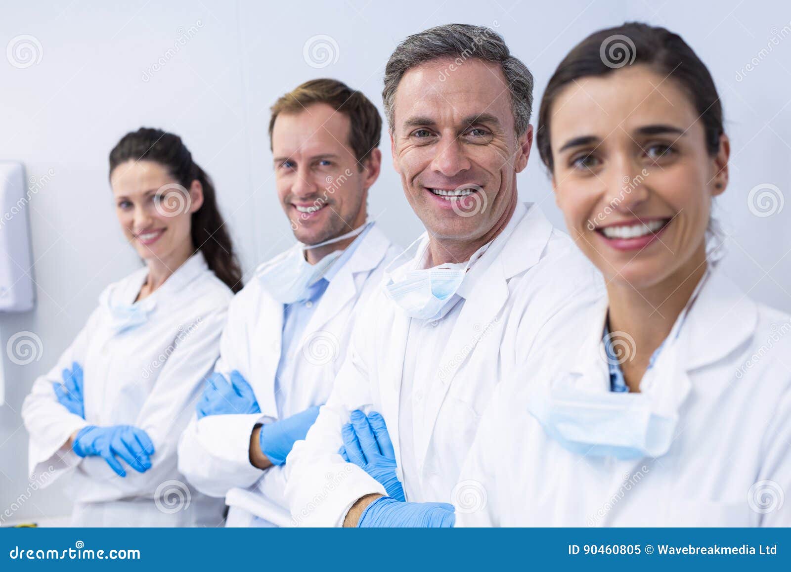 smiling dentists standing with arms crossed