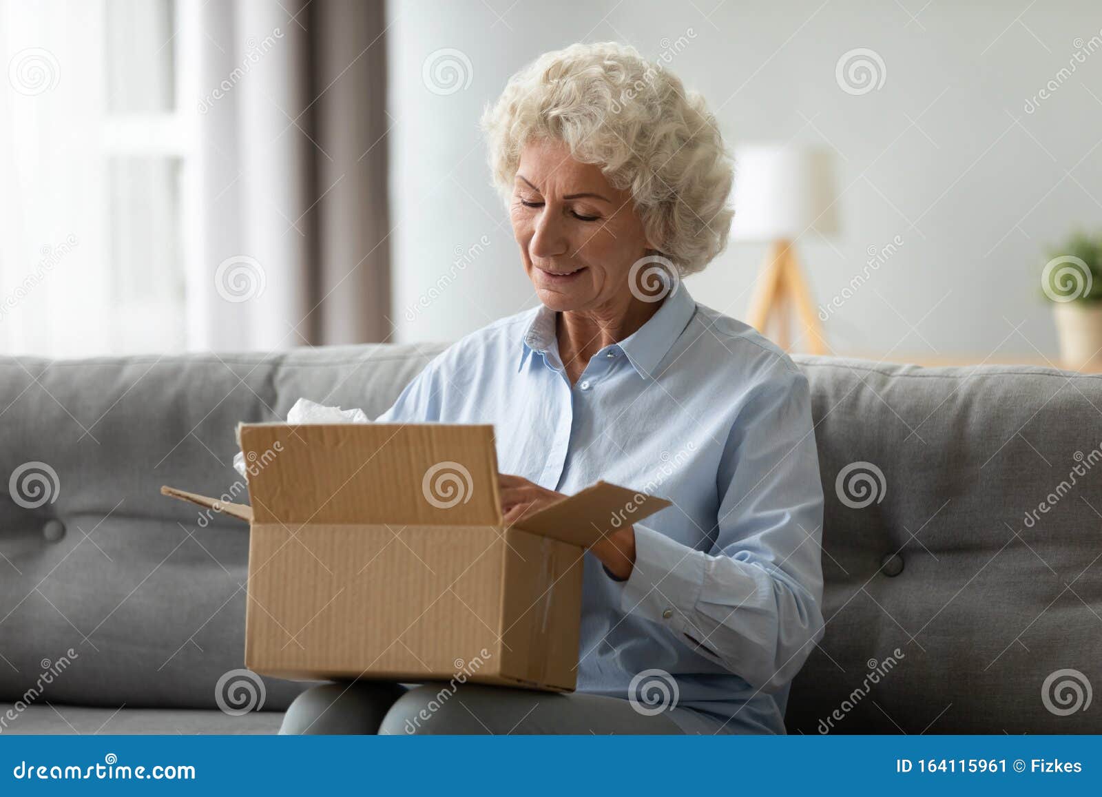 smiling elderly woman customer receive post shipment parcel at home
