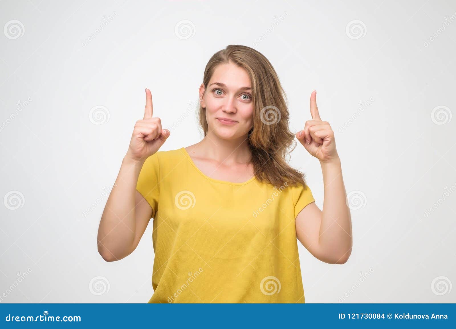 Smiling European Woman in Yellow Shirt Pointing Finger Up. Stock Photo ...