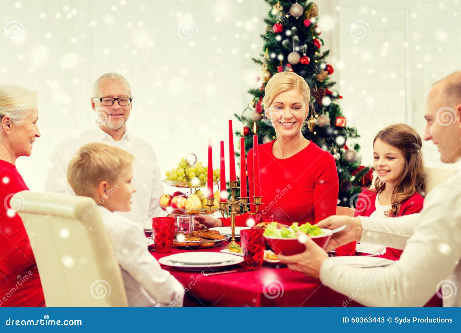 Smiling family having holiday dinner at home. Family, holidays, generation, christmas and people concept - smiling family having dinner at home