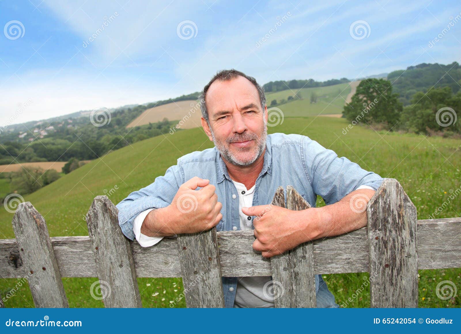 smiling farmer by the fence