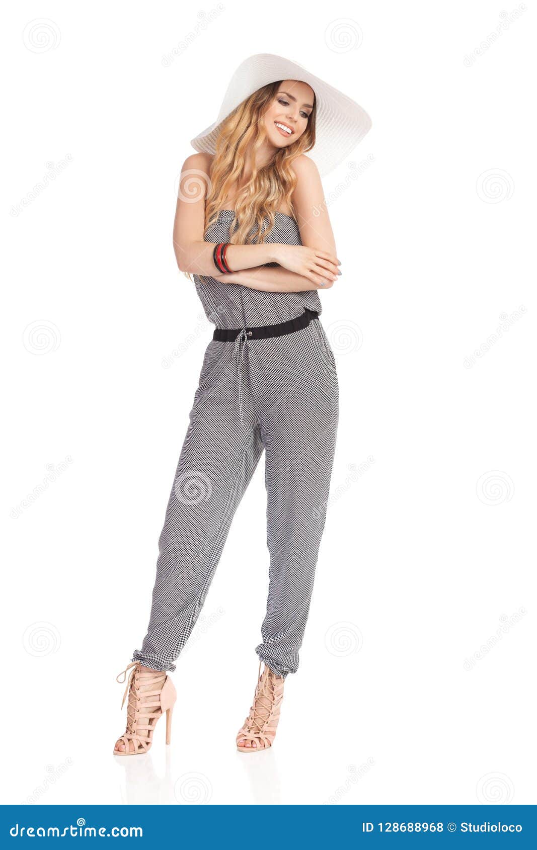 Smiling Fashion Model in Sun Hat, Jumpsuit and High Heels is Looking ...