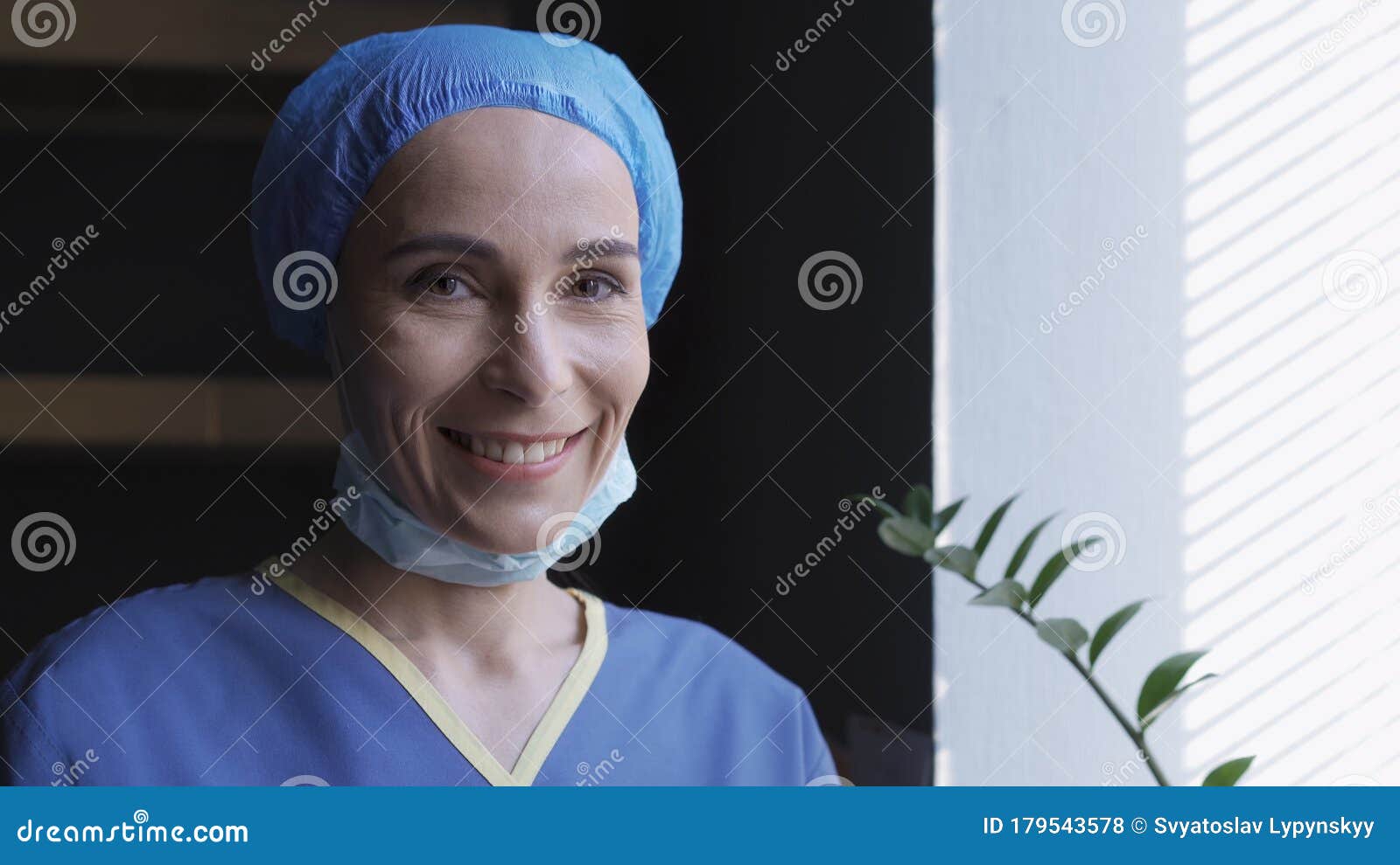 smiling female doctor rejoices standing near window