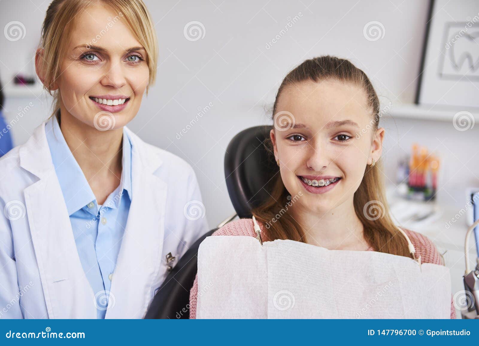 smiling female orthodontist and child in dentist`s office