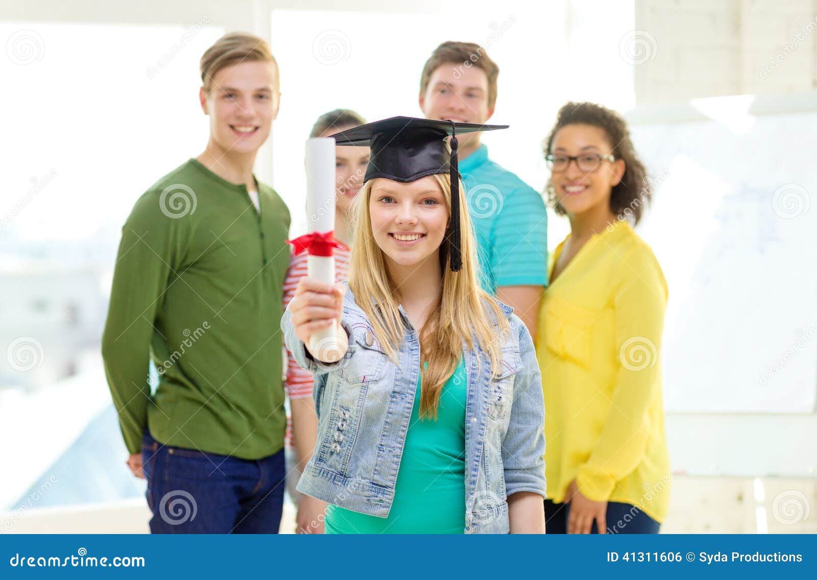 Portrait of graduate teen latin boy student in black graduation gown with  hat, holding diploma - isolated on background. Child back to school and  educational concept. Stock Photo