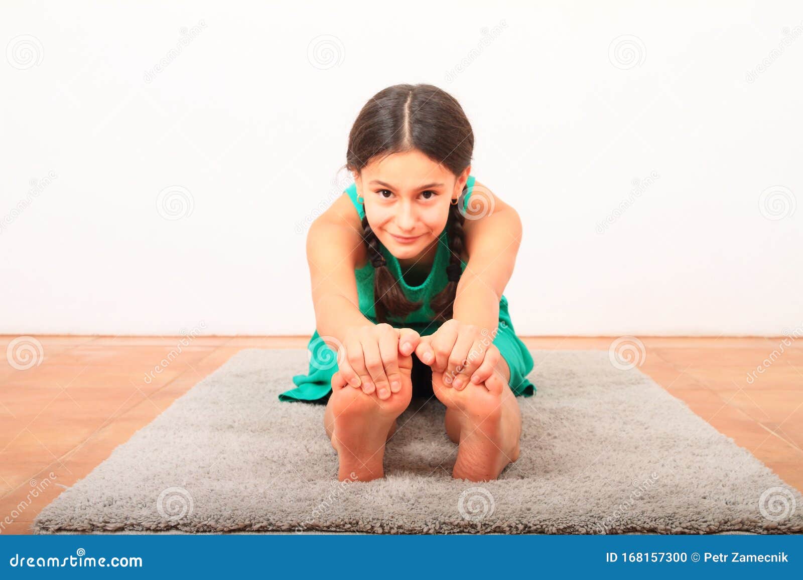 Smiling Girl Exercising Yoga - Seated Forward Fold Stock Photo - Image of  grey, dress: 168157300