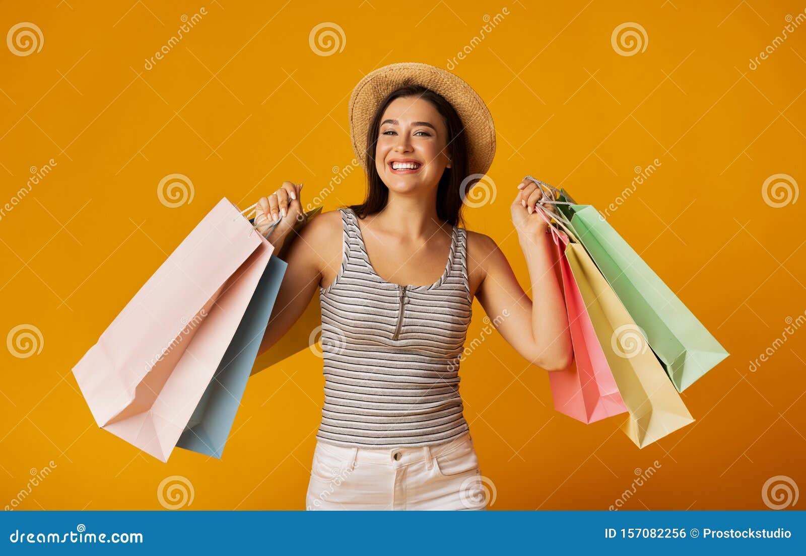 Download Smiling Girl Holding Colorful Shopping Bags On Yellow Studio Background Stock Photo Image Of Discount Sales 157082256 Yellowimages Mockups