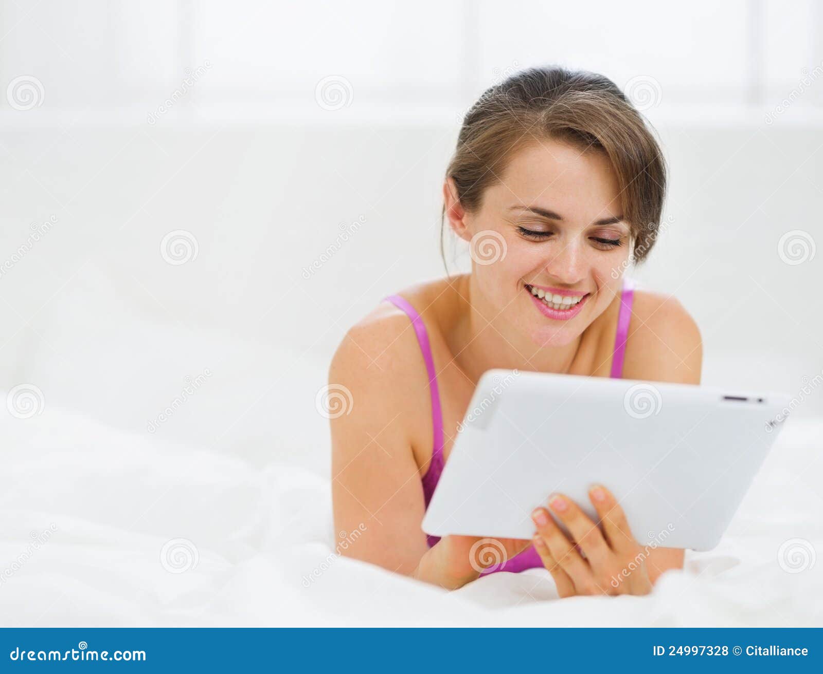 Smiling Girl Laying in Bed and Using Tablet PC Stock Photo Image of