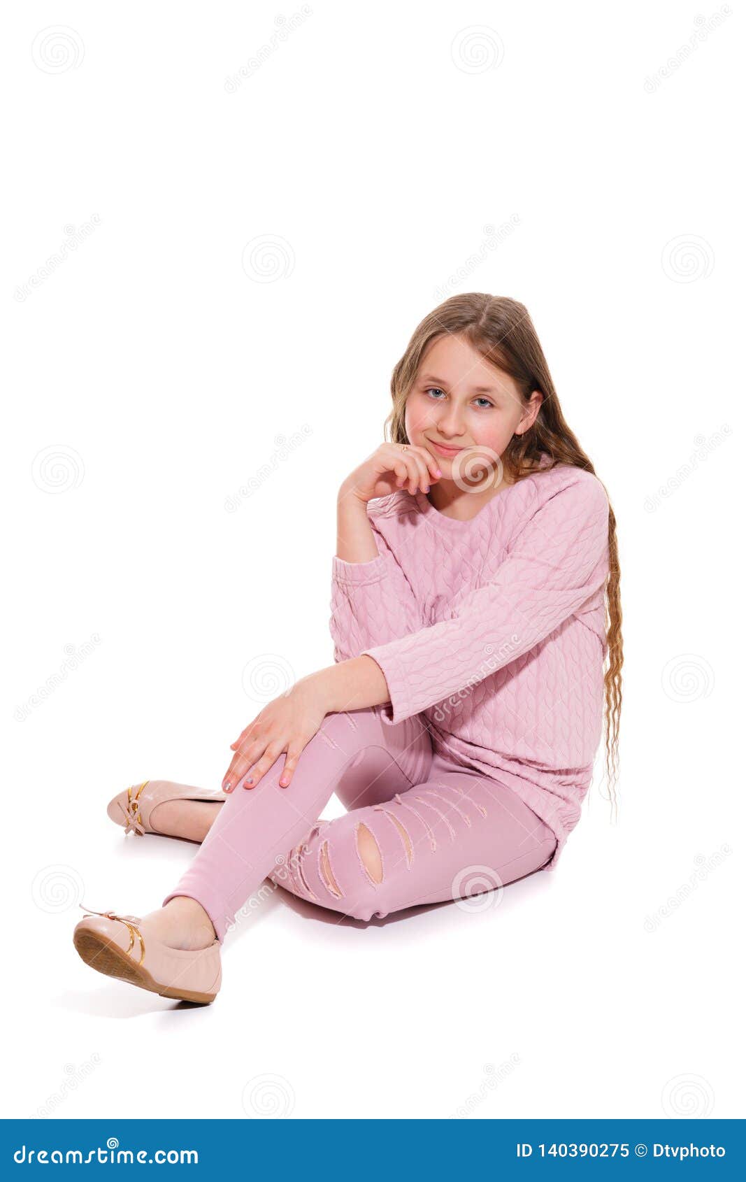 A Smiling Girl in a Pink Suit is Sitting on the Floor. Isolation on a ...