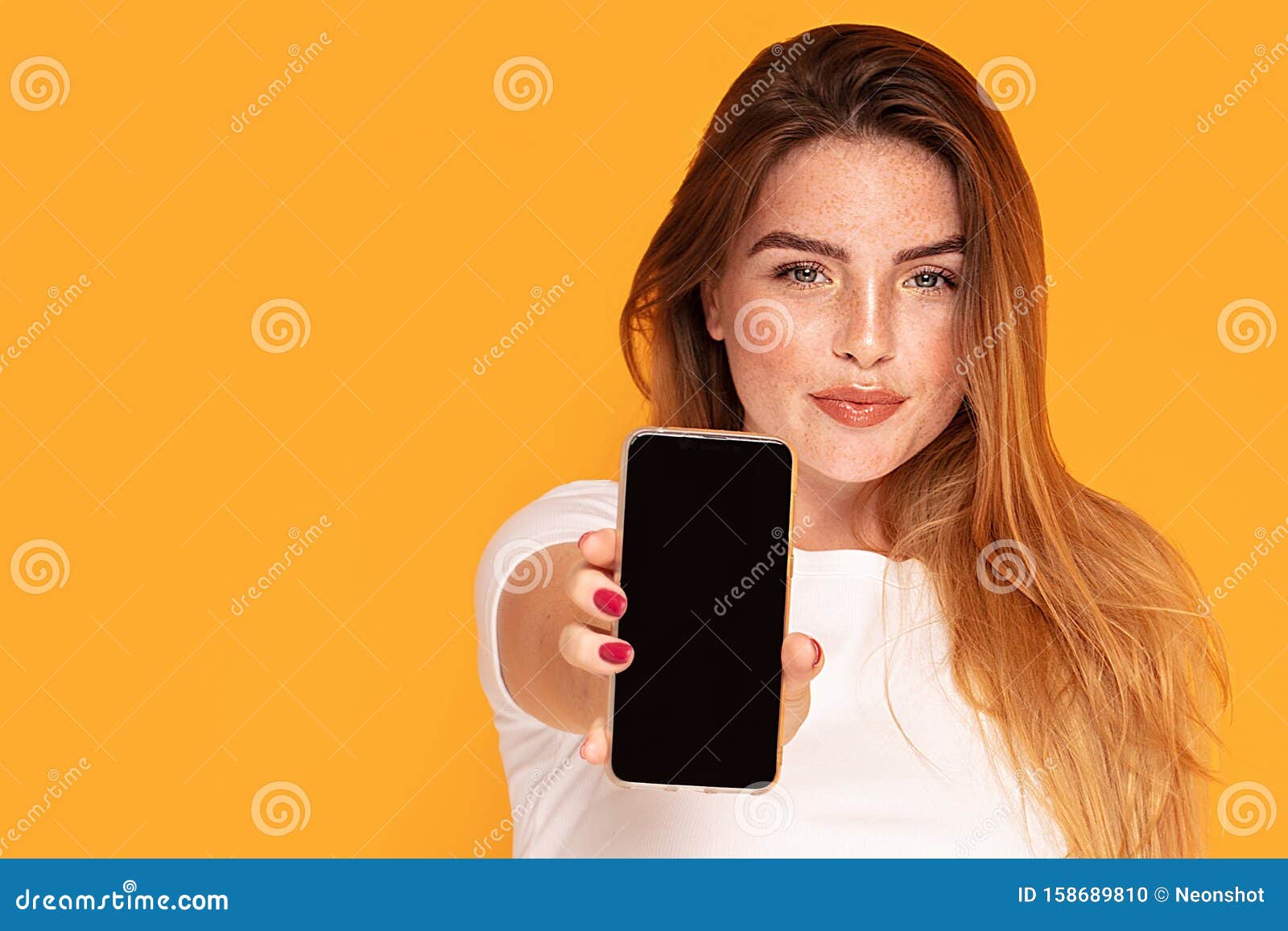 smiling girl showing mobile phone with empty screen