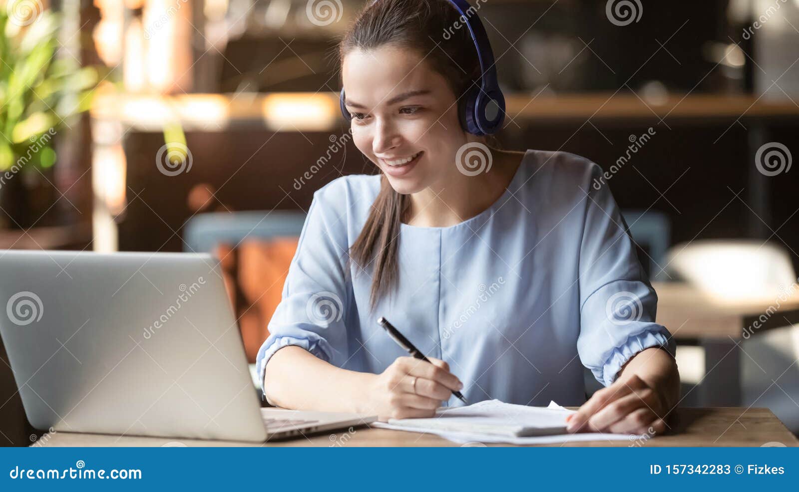 smiling girl wear wireless headphone study online with skype teacher