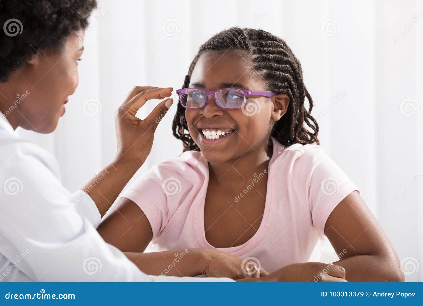 smiling girl wearing eyeglasses in front of optometrist