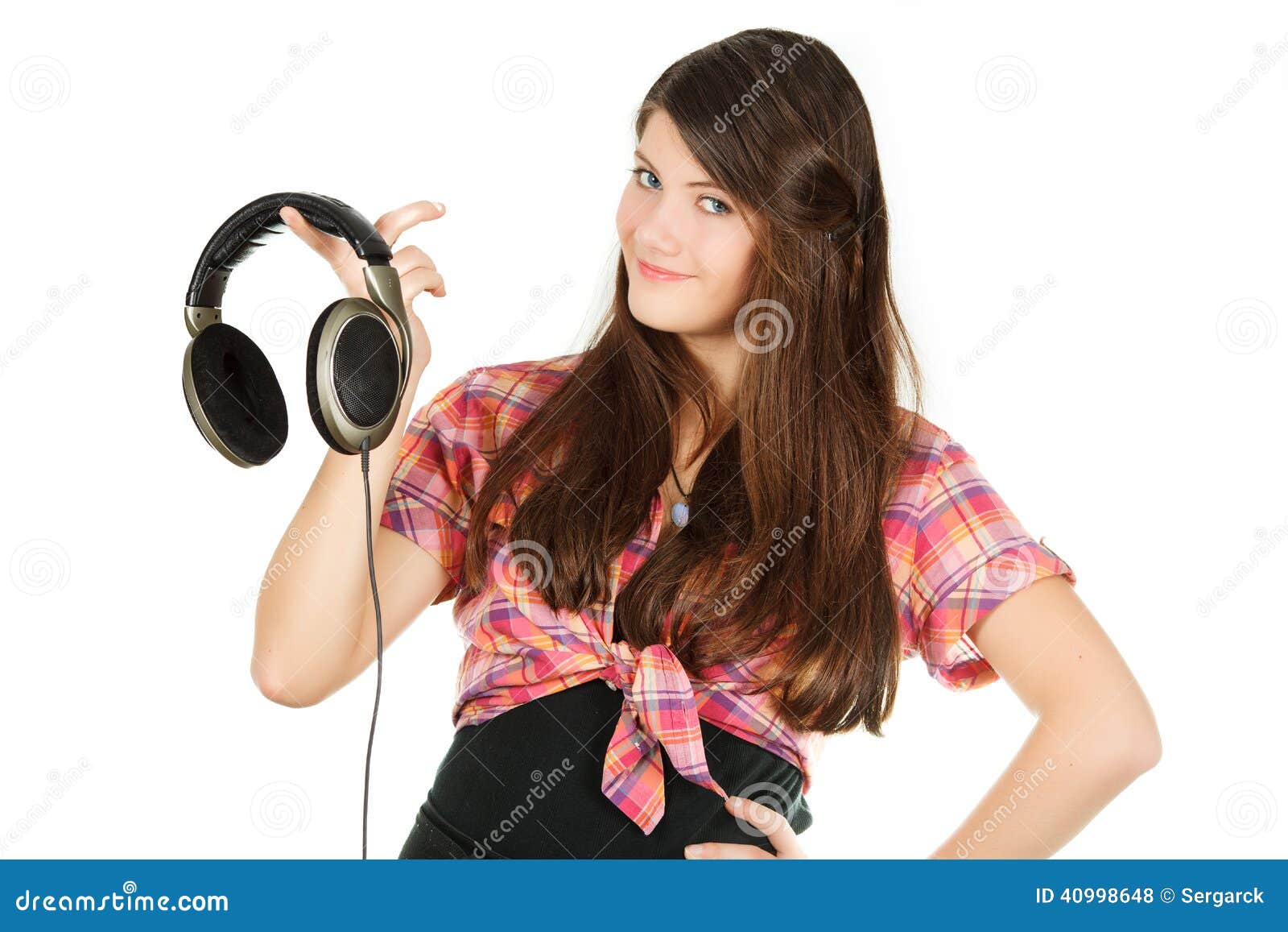 A smiling happy girl holds headsets in a hand, isolated on a white background