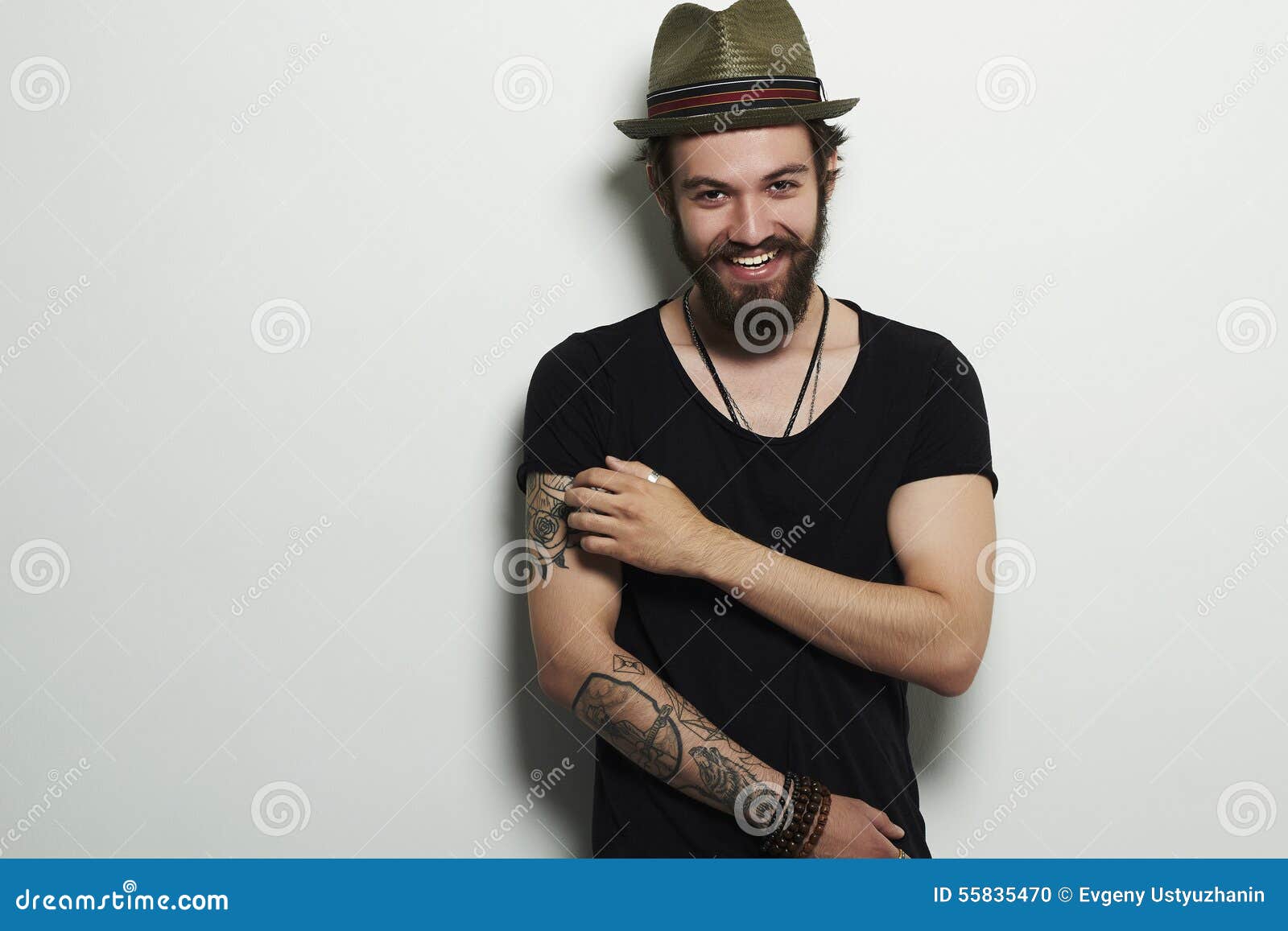 smiling hipster boy. handsome man in hat. brutal bearded boy with tattoo