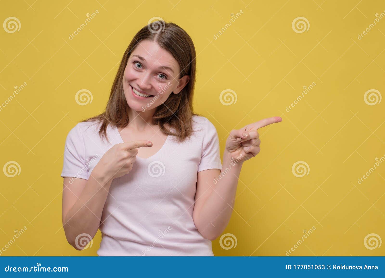 smiling joyful woman pointing at copy space for advertisment or promotional text