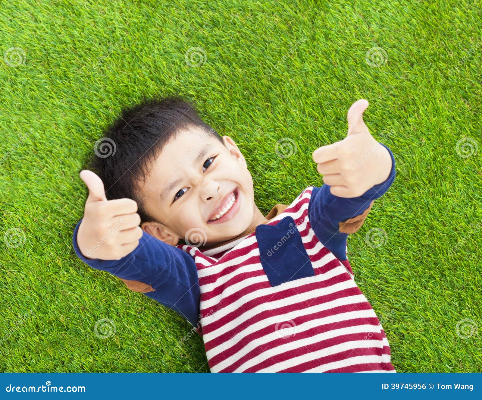 Smiling Kid Lying And Thumb Up On A Meadow Stock Photo Image Of Asian
