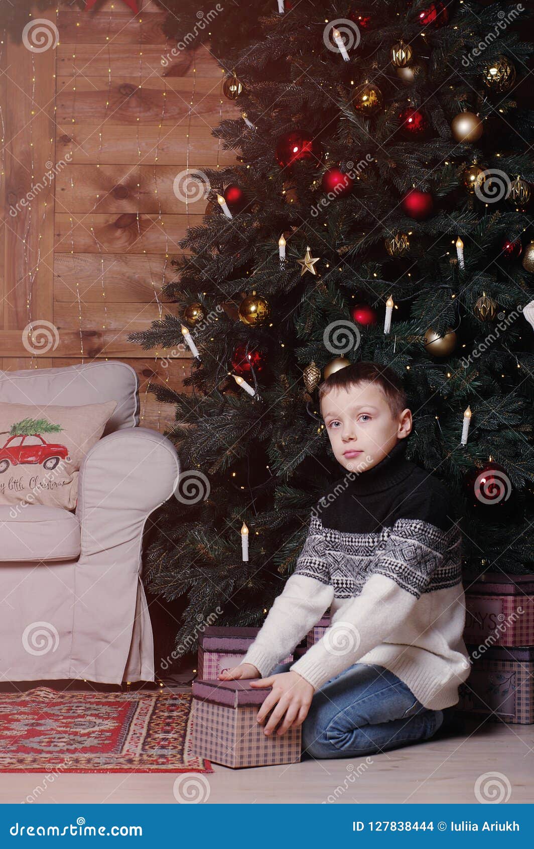 Smiling Little Boy with the Present Box Under the Christmas Tree Stock