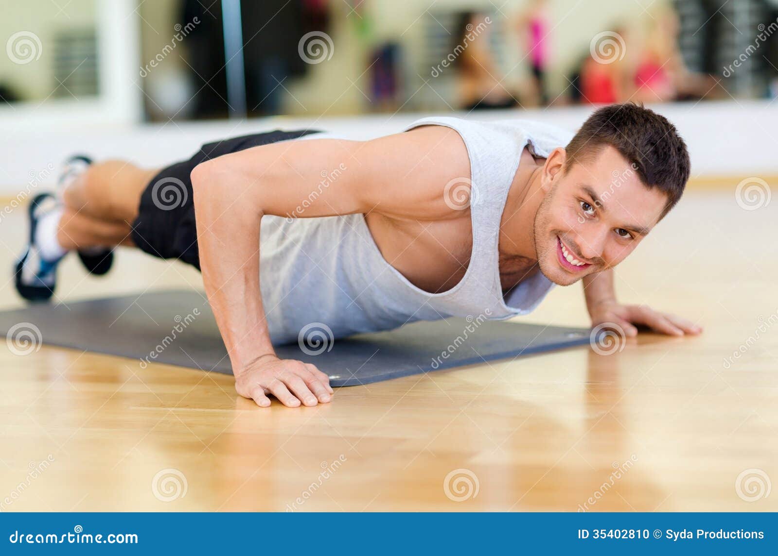 smiling man doing push-ups in the gym