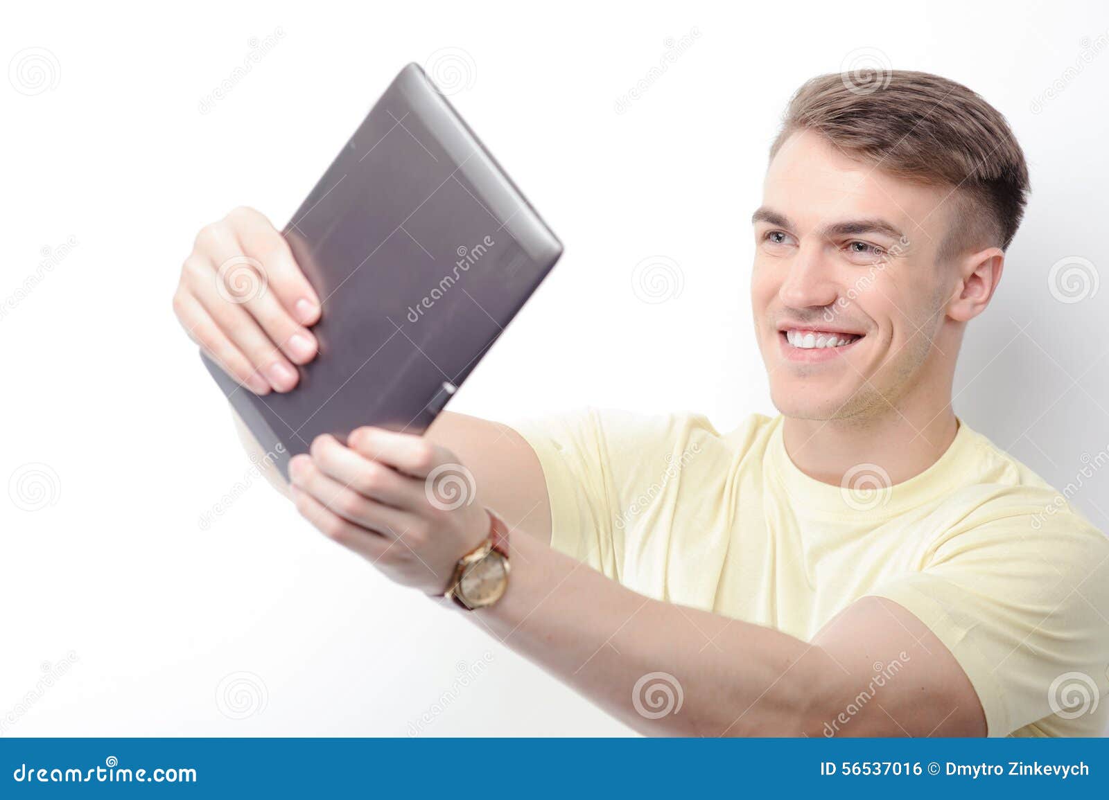 smiling man holding tablet in front of him