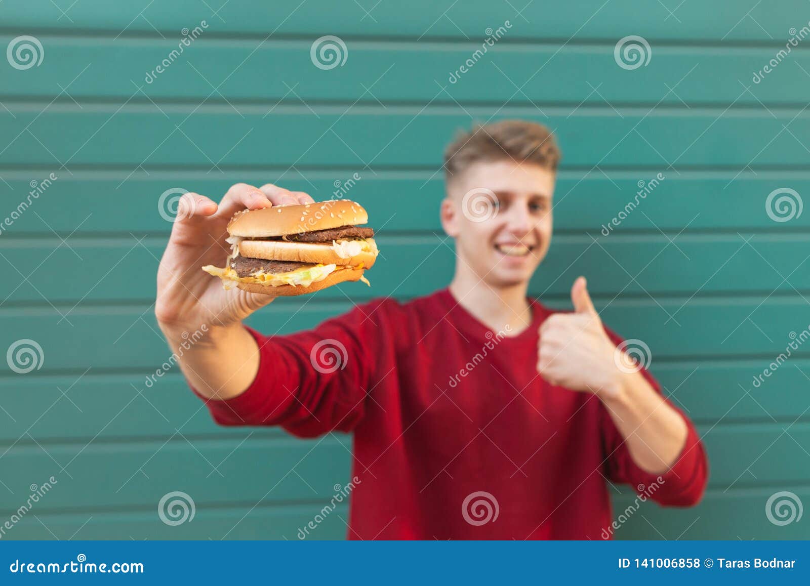 Smiling Man Holds An Appetizing Burger In His Hands And ...