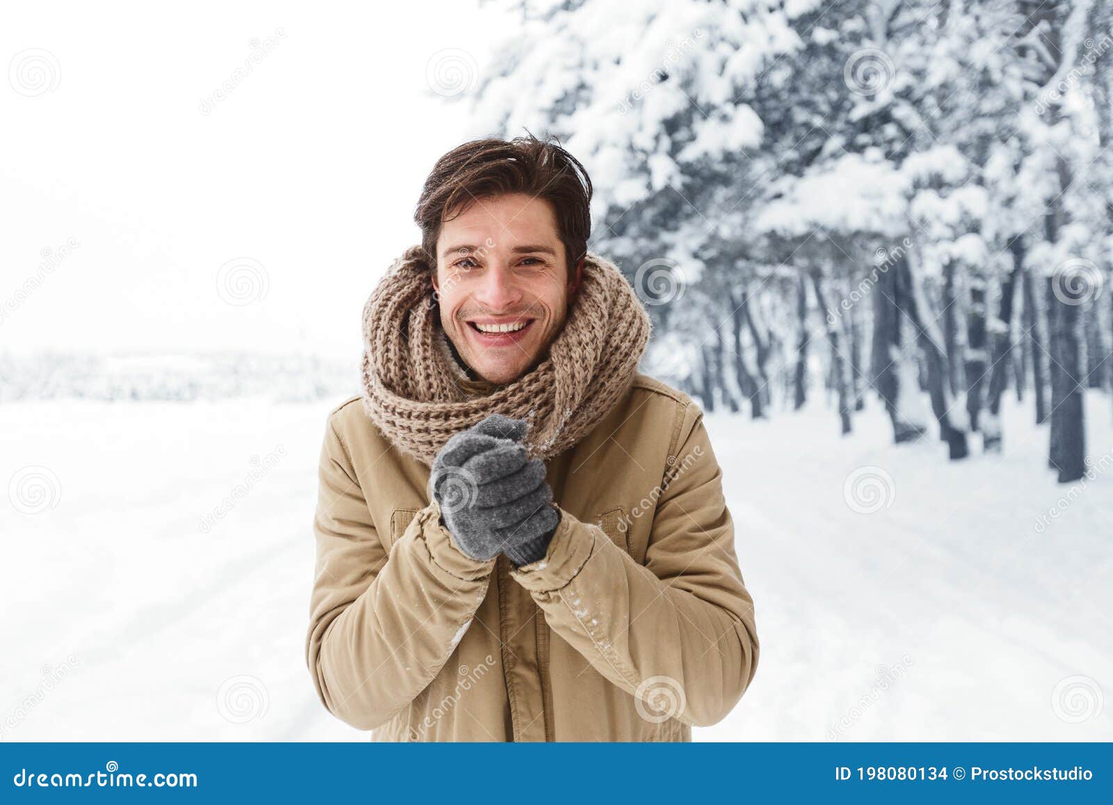 Smiling Man Rubbing Hands in Gloves Standing in Snowy Park Stock Photo ...
