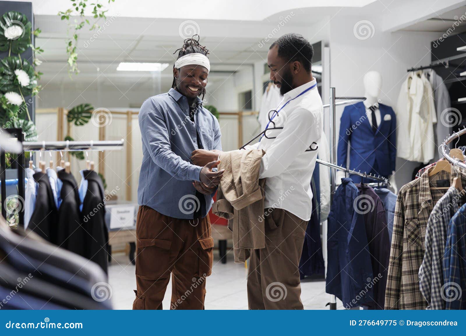 Smiling Man Trying on Shirt and Discussing with Salesperson Stock Image ...