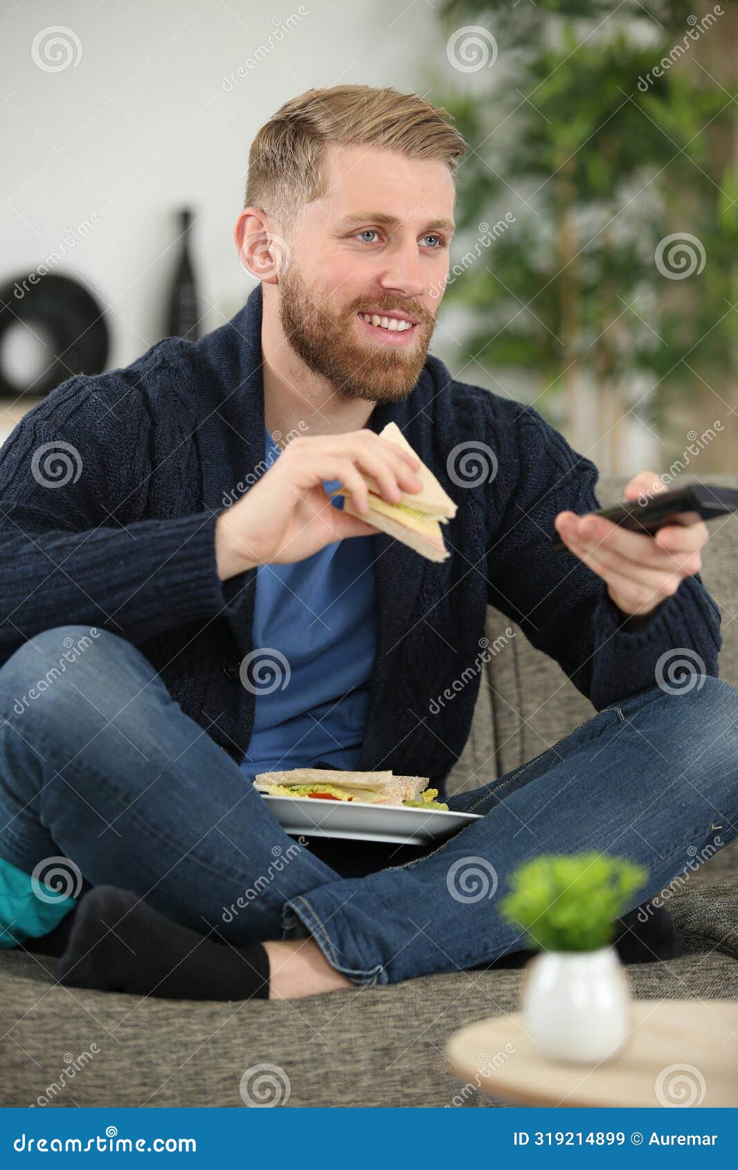 Smiling Man Watching Tv while Eating Sandwich Stock Image Image of