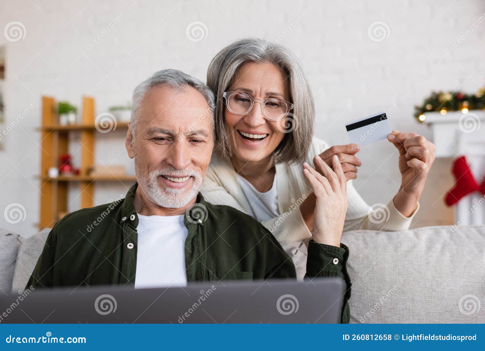 smiling mature man using laptop near