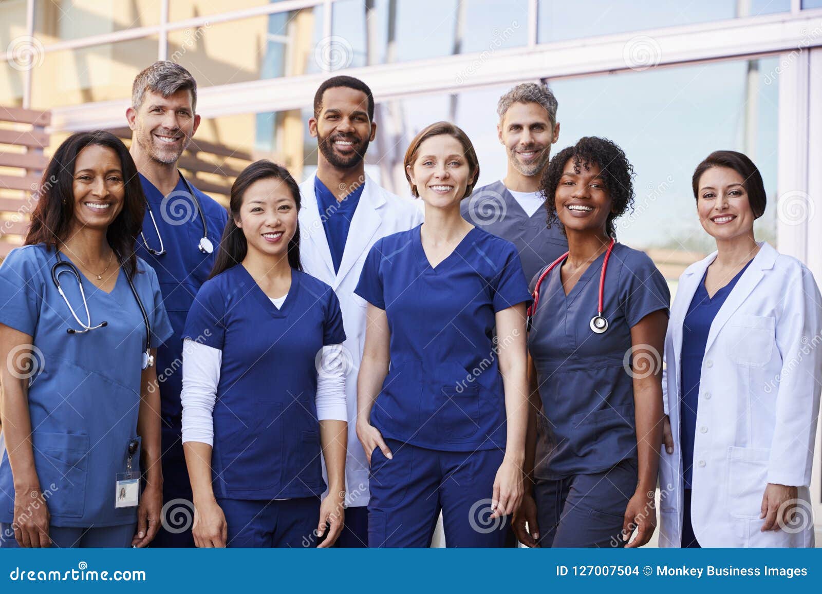 smiling medical team standing together outside a hospital