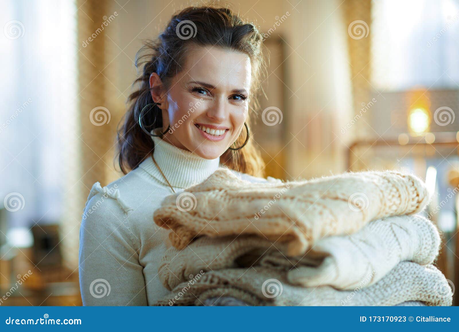 Smiling Modern Middle Age Woman Holding Pile of Sweaters Stock Image ...