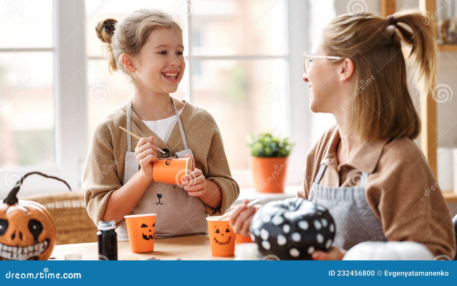 Smiling Mother and Daughter Sitting at Wooden Table and Making ...